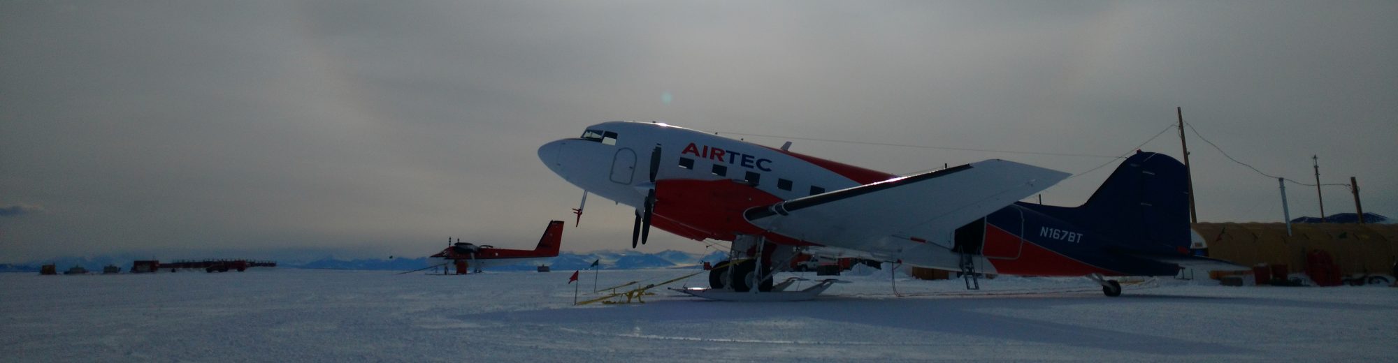 A plane in a snowy area during sunset.